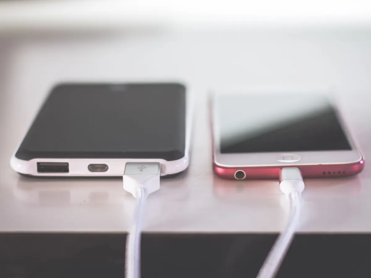 A power bank and a phone charging on braided cables